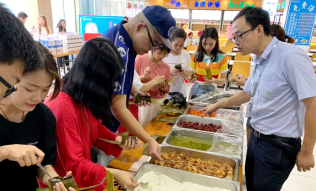 我公司三亞學(xué)院分店端午節現場傳授學(xué)生包粽子活動